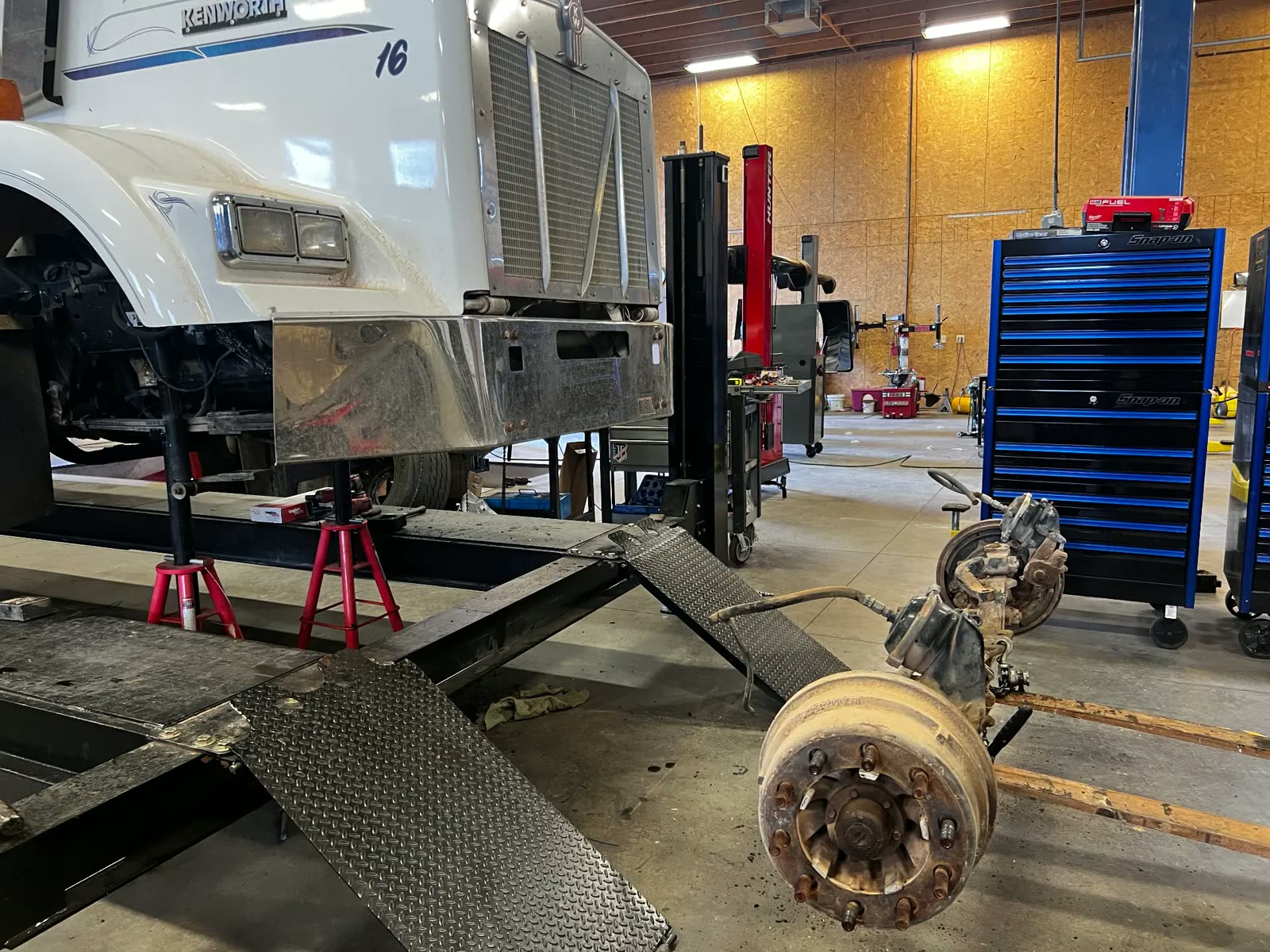 Kenworth semi on stands with the front axle removed for service