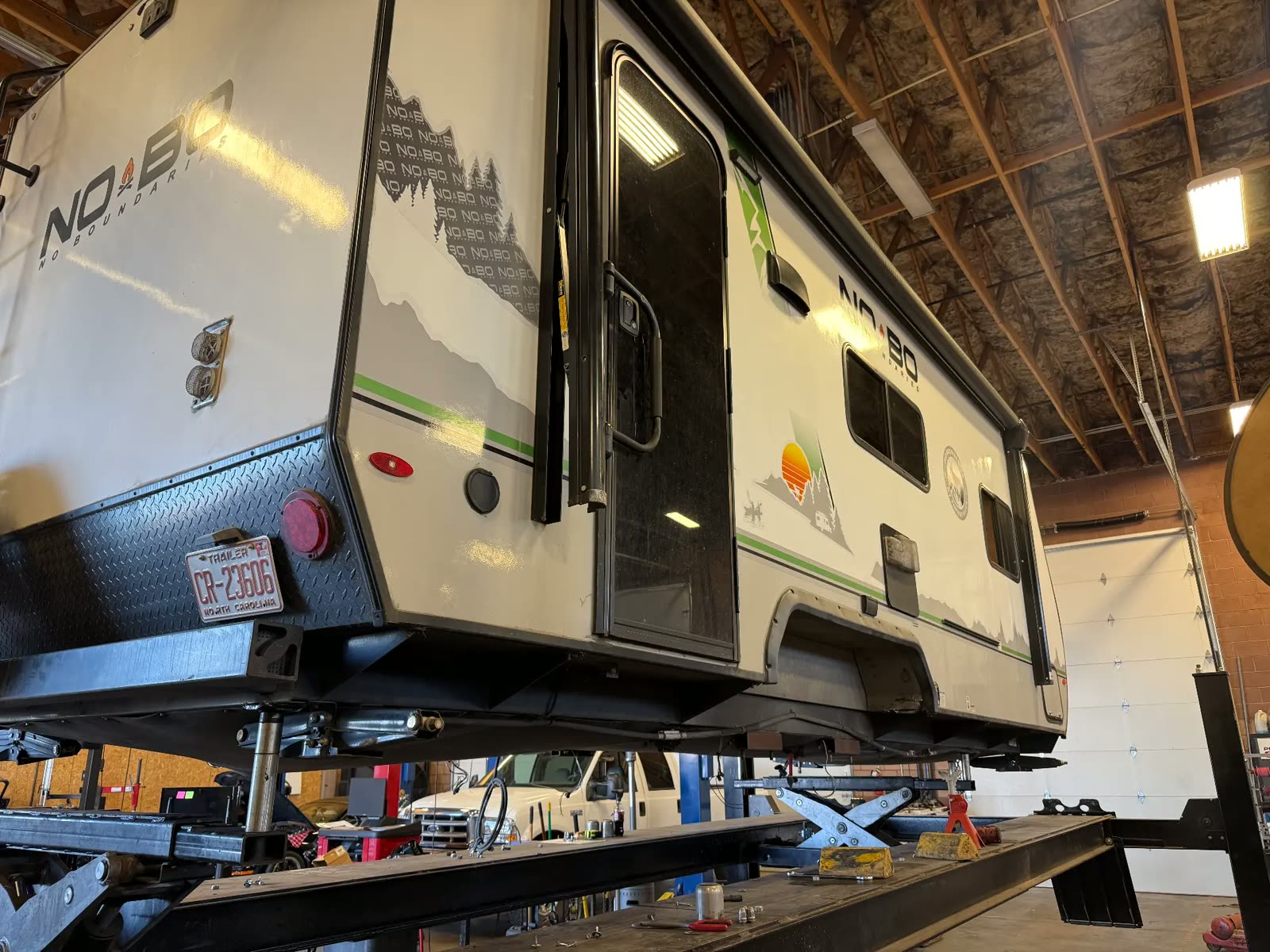 No Boundaries truck camper lifted in the MPA service bay