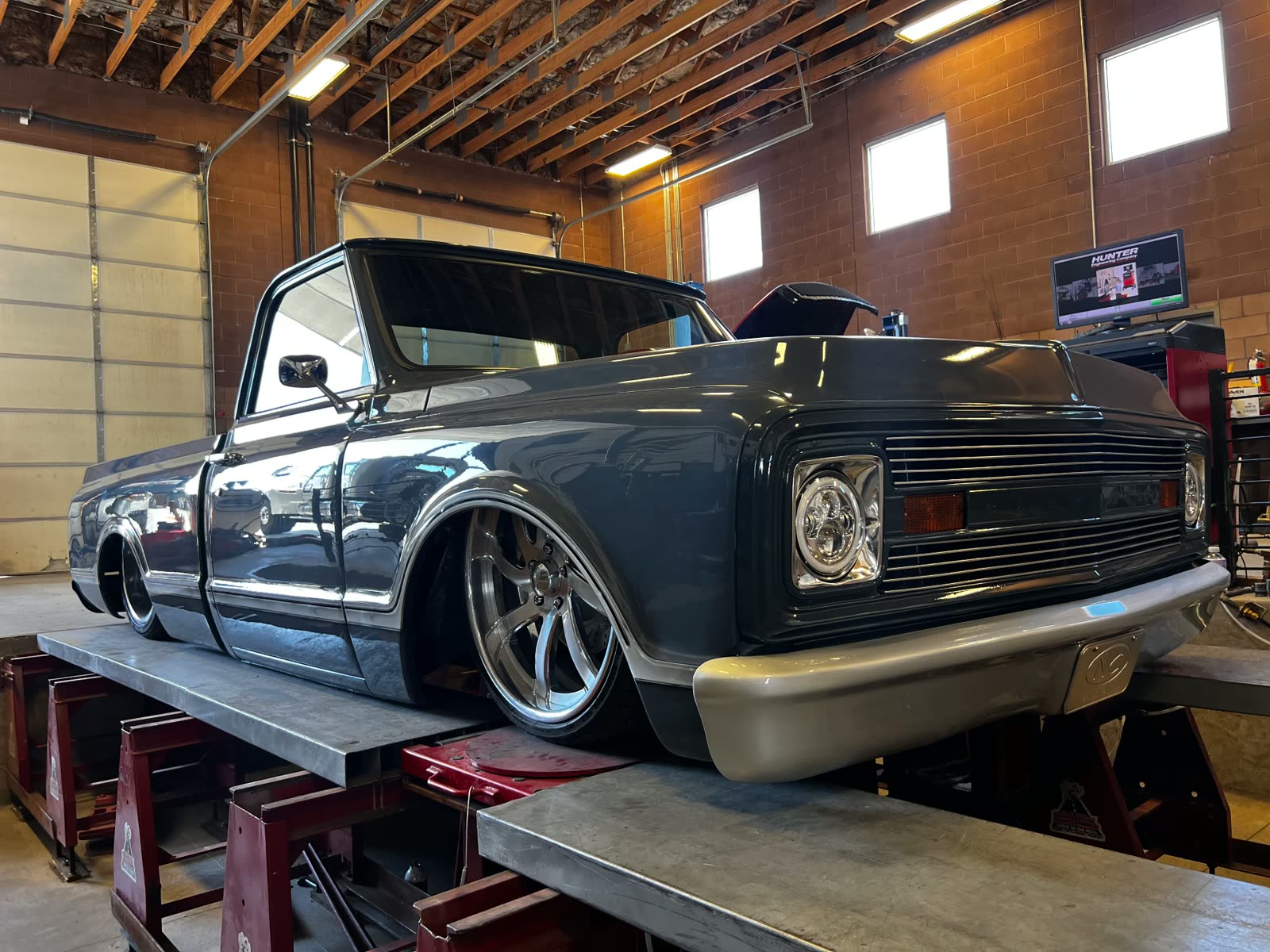 Bagged custom Chevrolet C10 pickup laid out on the alignment rack