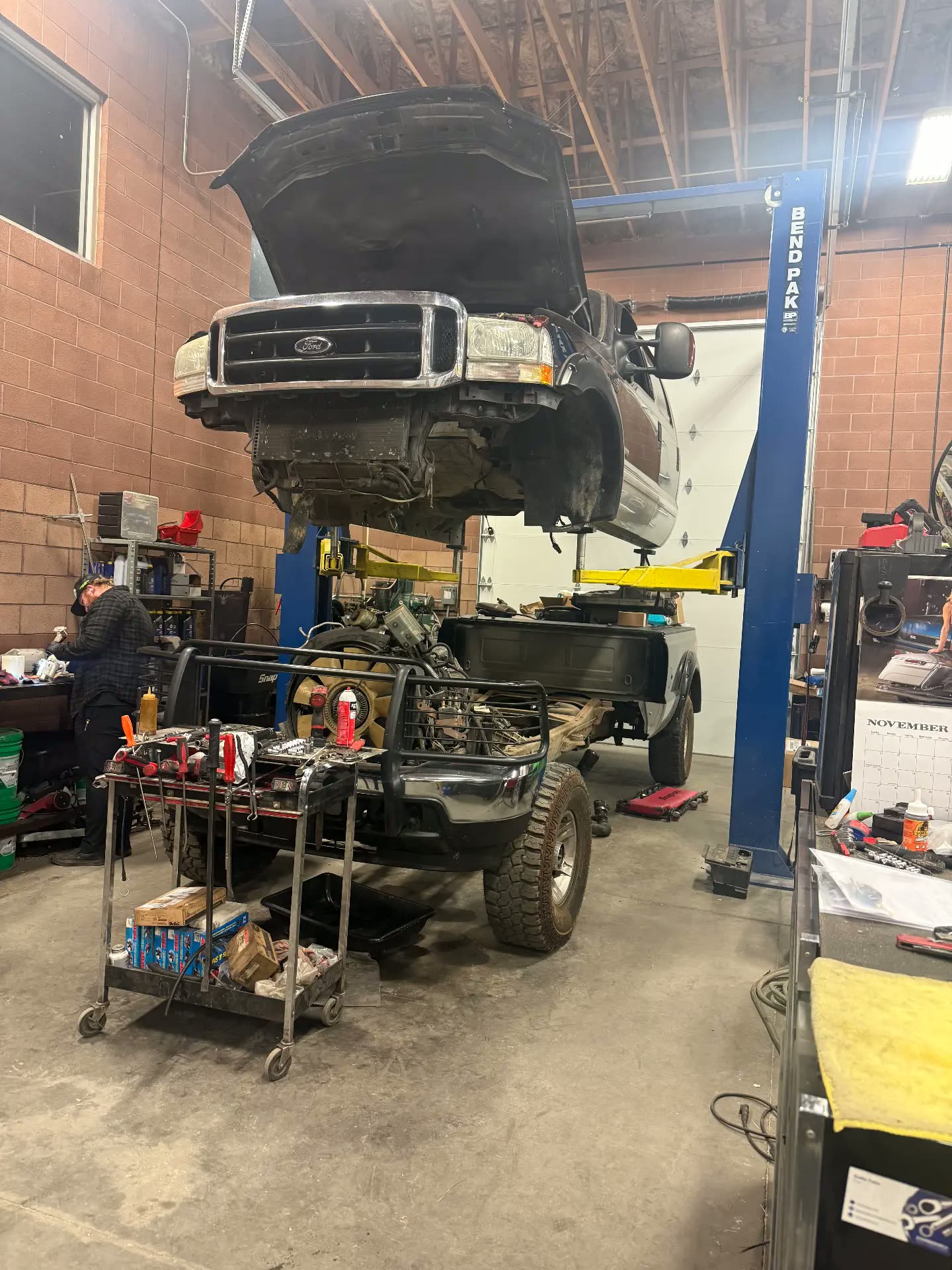 Ford Super Duty on the lift with the bed and engine pulled for a rebuild
